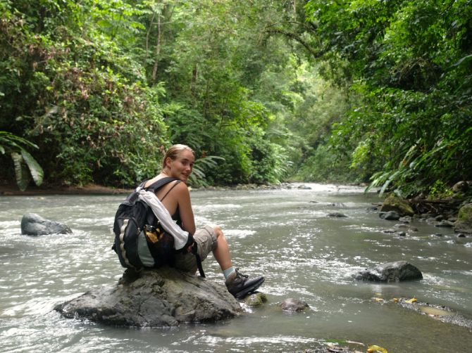 Escalador sentado en roca en el rio del Parque Nacional Corcovado