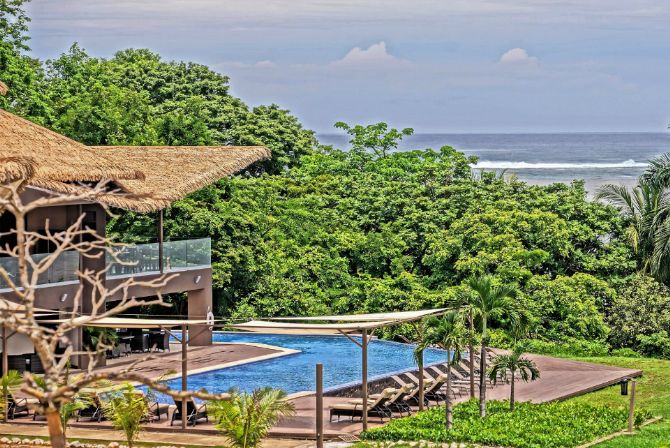 Vista de la piscina y la playa de Nammbú Beach Front Bungalows