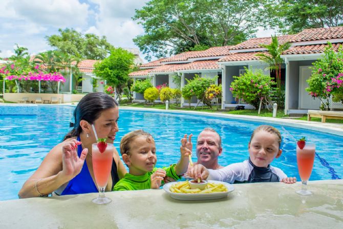 Familia disfrutando de la piscina y la comida